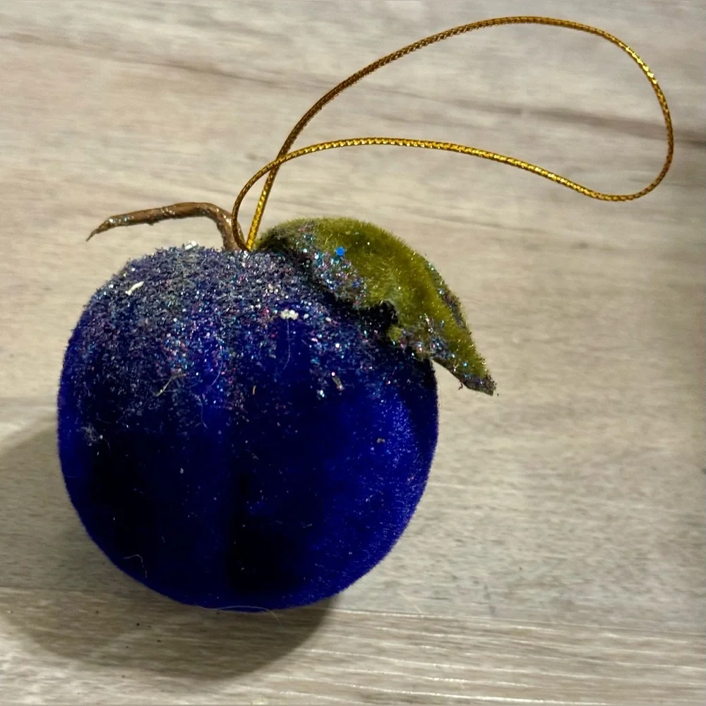 Christmas tree ornament. A plum-shaped ornament covered in glitter. The ornament